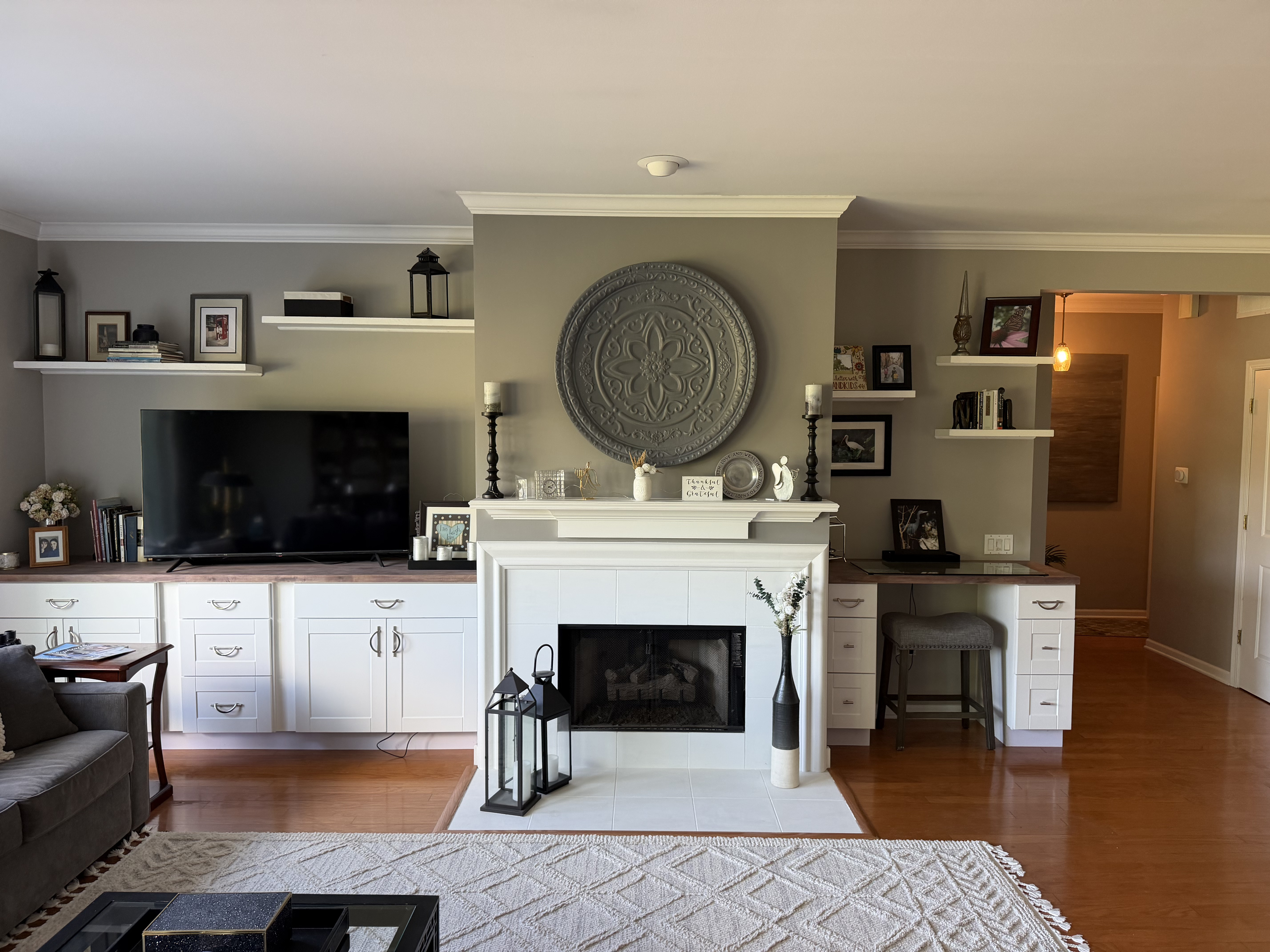 Remodeled living room with white built-in cabinets, fireplace and decorative wall medallion